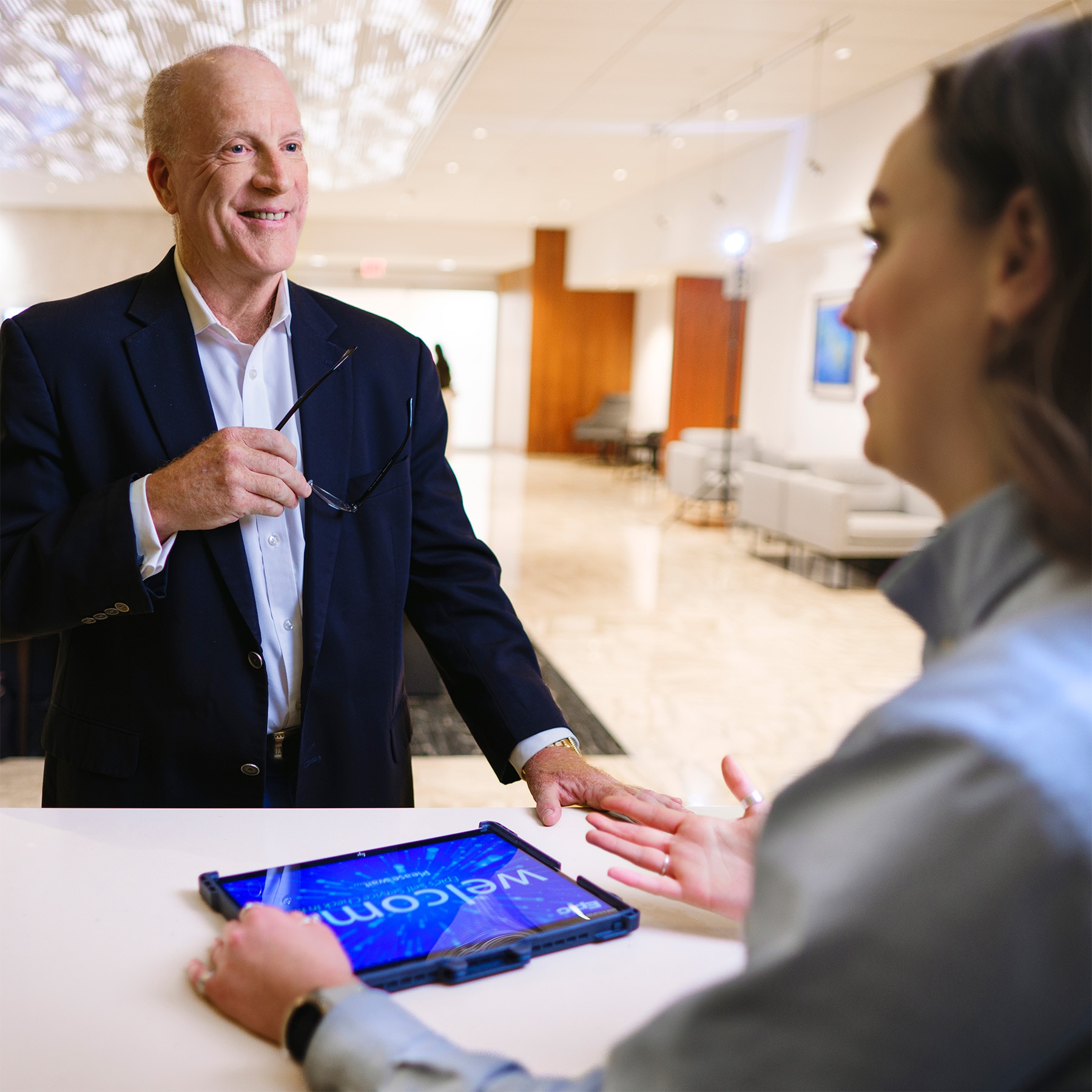 Concierge staff member welcoming a guest in a Mayo Clinic hospitality area, offering personalized assistance.