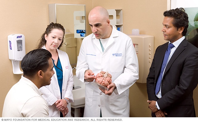 Neurólogos y neurocirujanos de Mayo Clinic conversan con un paciente.