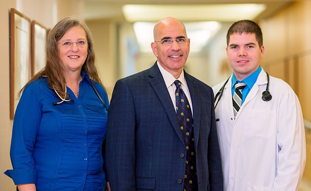 A group of healthcare professionals stands in a hallway.