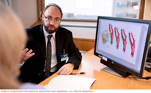 Mayo Clinic neurologist converses with a woman about possible carotid artery disease diagnosis.