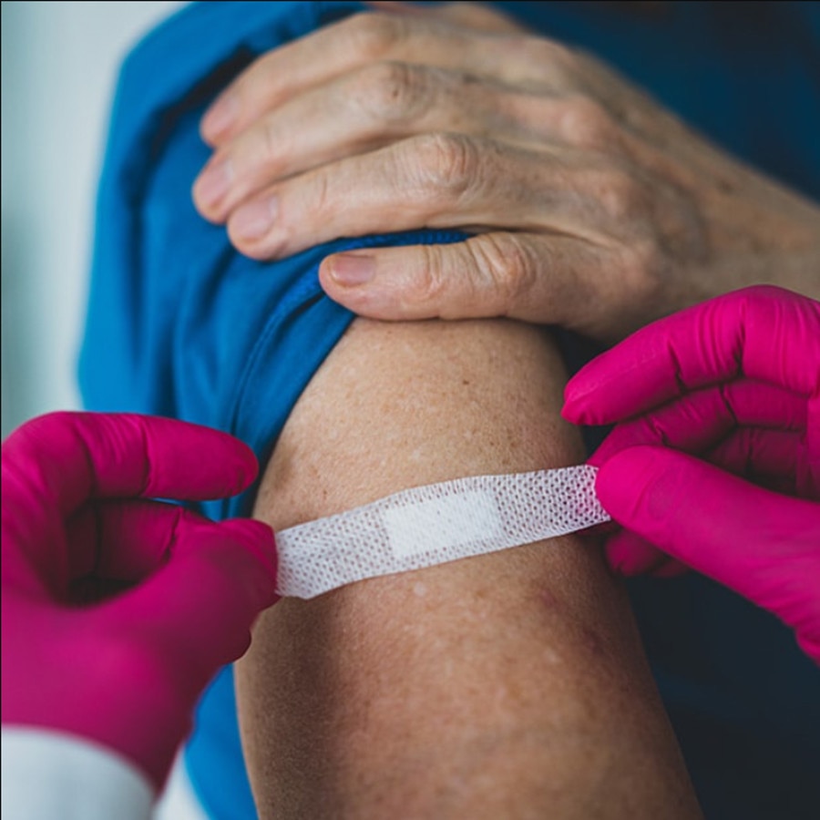 Provider applying Bandaid to upper arm
