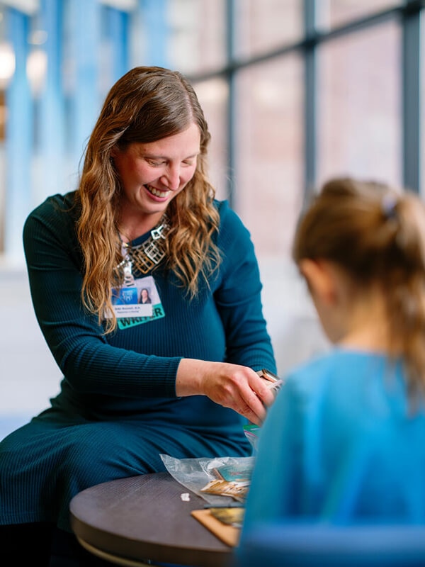 A healthcare provider works on an art project with a child.