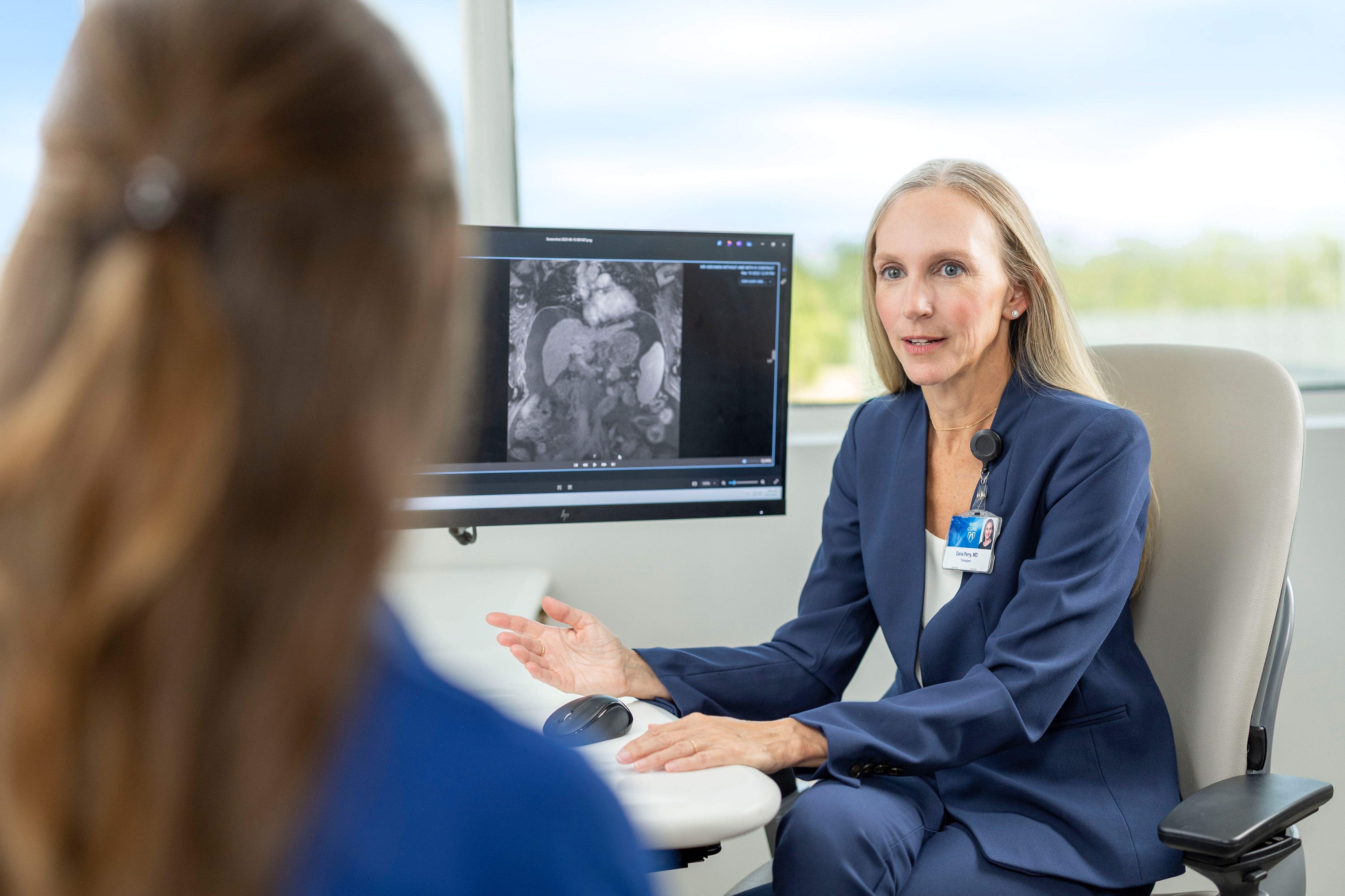 Mayo Clinic transplant surgeon reviews medical imaging with a patient.