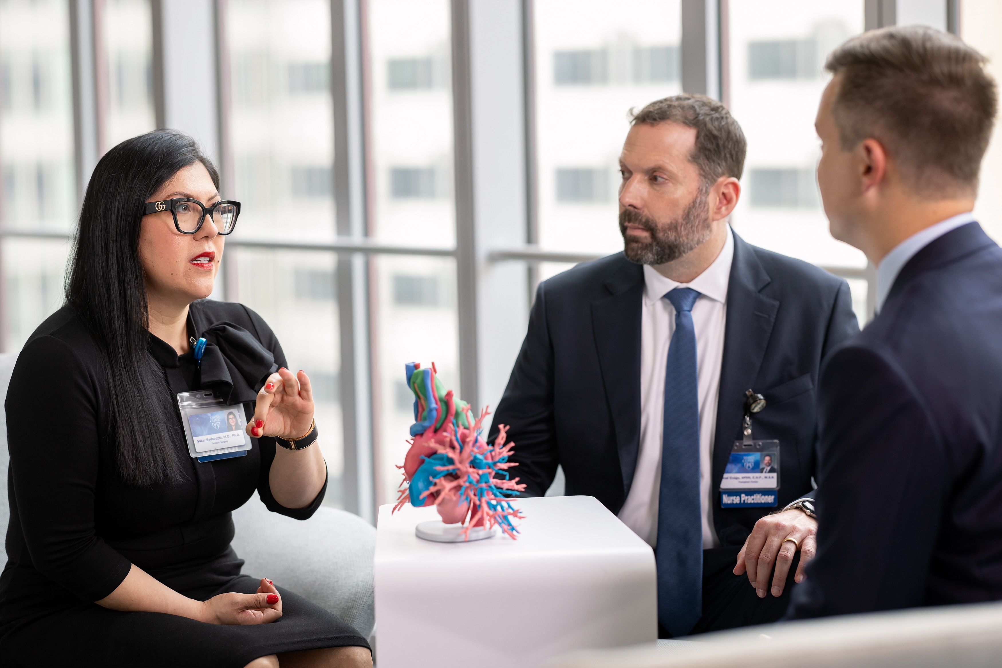 Three Mayo Clinic transplant team members review a 3D-printed anatomical model.